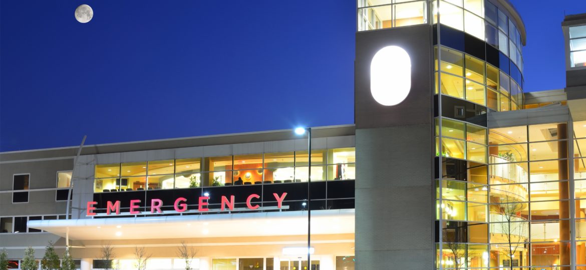 Exterior of a hopsital Emergency Room lit up at night